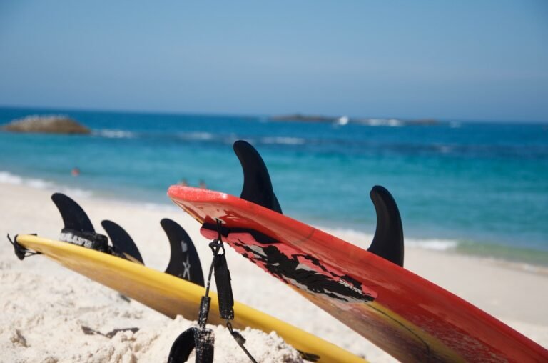 Rental surfboards lined up on the beach in Faro, Algarve