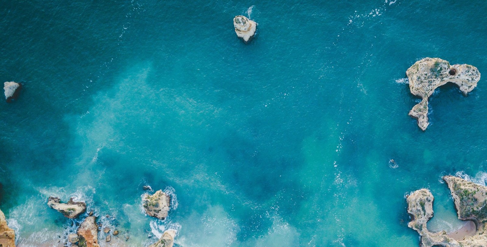 Aerial view of turquoise water and sea caves in the Algarve, Portugal