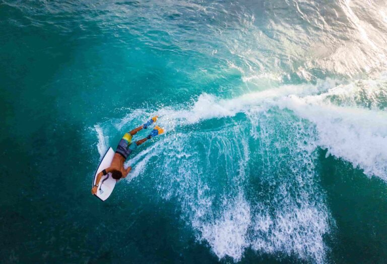 A bodyboarder riding a turquoise wave in the Algarve