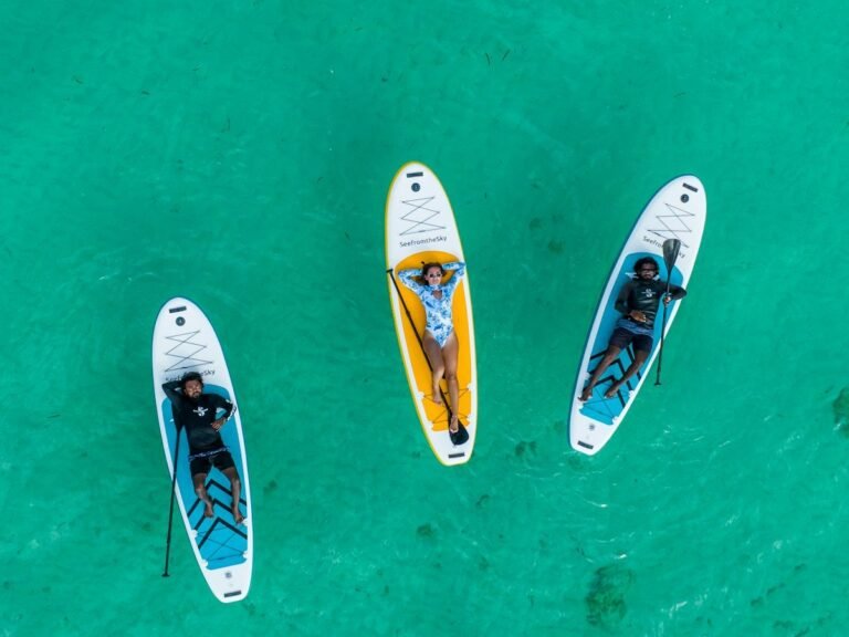 Three stand-up paddleboards on turquoise water, seen from above