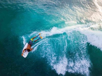 A bodyboarder riding a turquoise wave in the Algarve