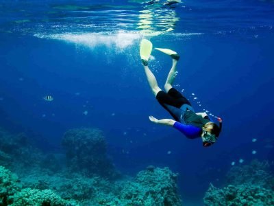 Person snorkeling in clear blue water in the Algarve, Portugal
