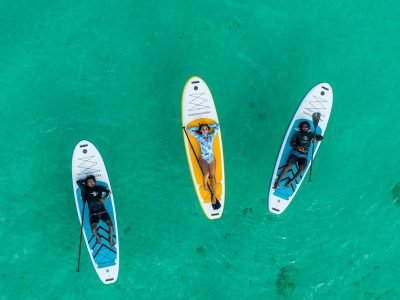 Three stand-up paddleboards on turquoise water, seen from above